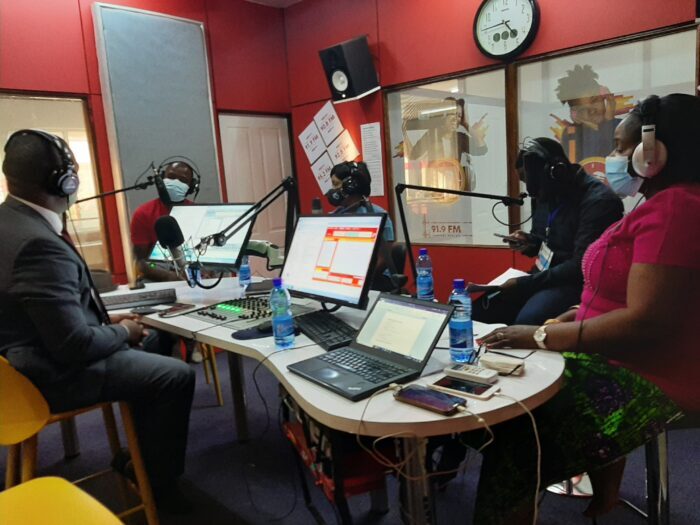 A group of people wearing face masks in a radio studio