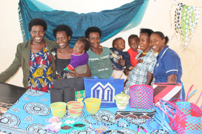 Photo of Merab Sanyu with young women she councils and the handicrafts the make.