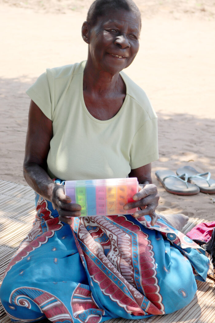 Isabel Tinga, 75, a cassava farmer in central Mozambique, with the tuberculosis medicine that brought her back to health. 
