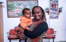 Dr. Sajida holding a child at an EGPAF partner site.