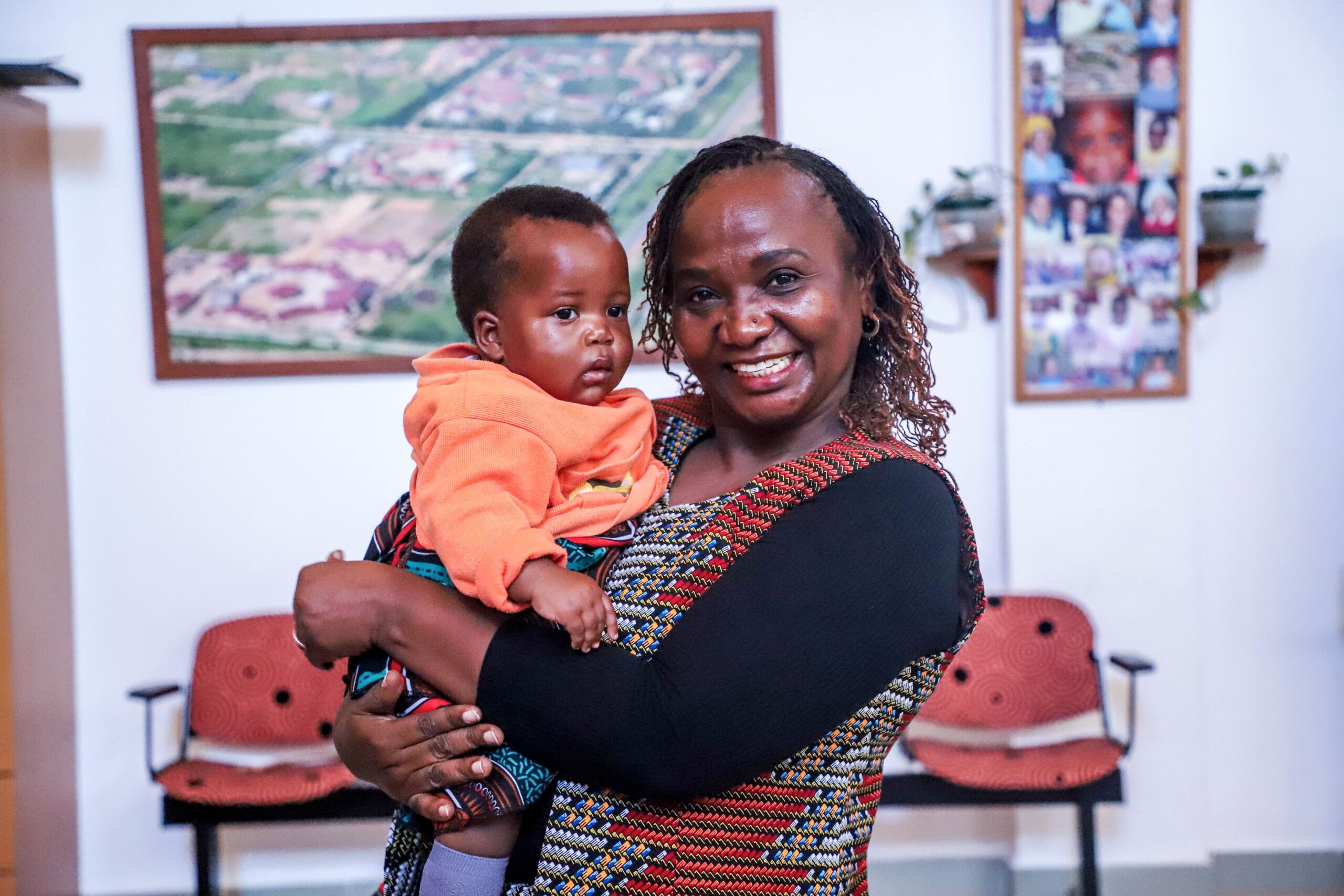 Dr. Sajida holding a child at an EGPAF partner site.